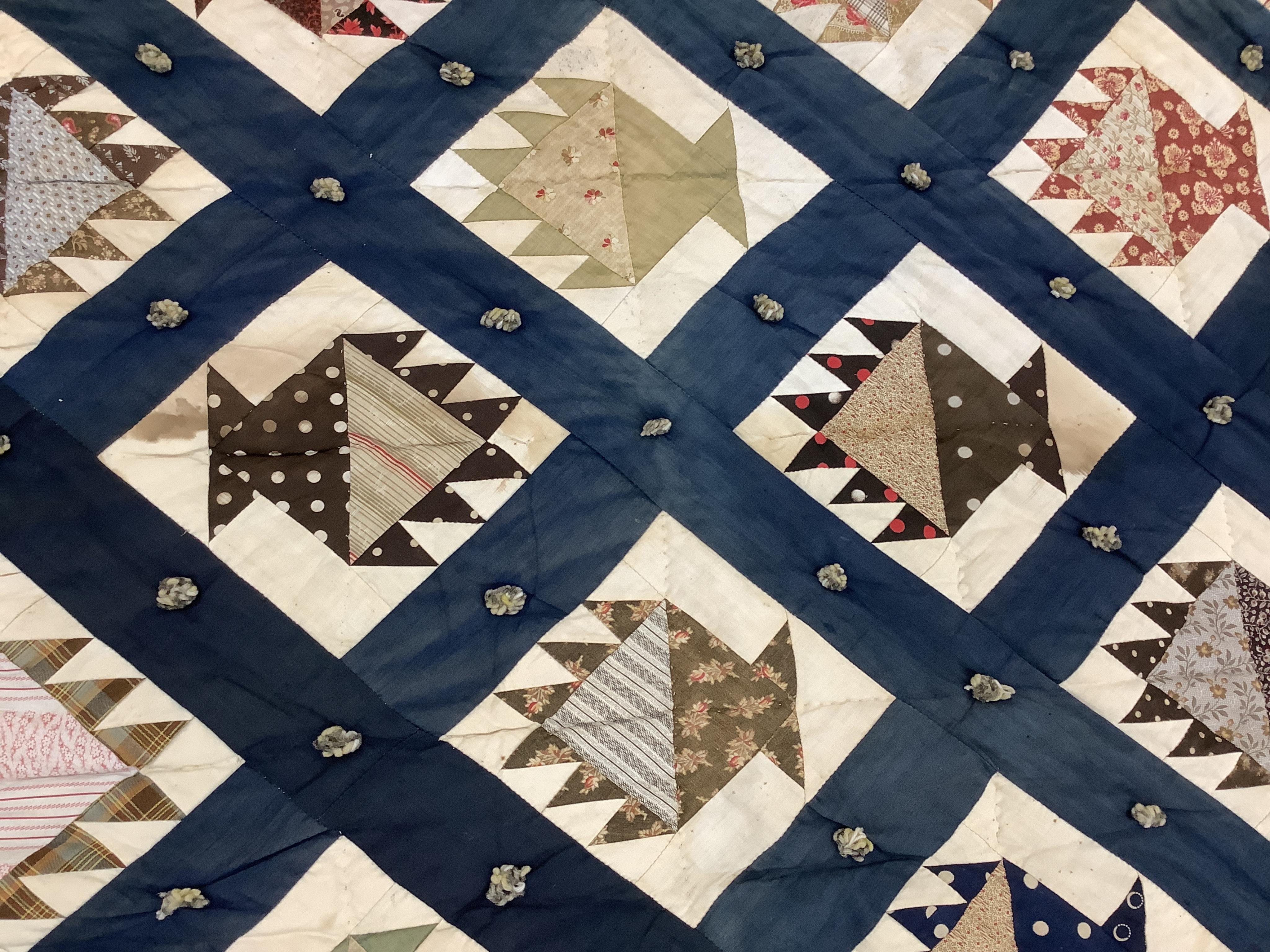 A bold handsome, American, Vermont 1865 (Civil War) ‘basket’ and lattice, hand quilted and piece tied bedcover, with an ornate floral backing. Worked with a plain navy cotton lattice border around central stylised printe